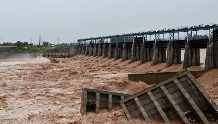 Damaged cemented blocks lie in the water beside an under-construction dam on the Tawi River, following heavy rainfall in IIOJK on August 27, 2025. — Reuters