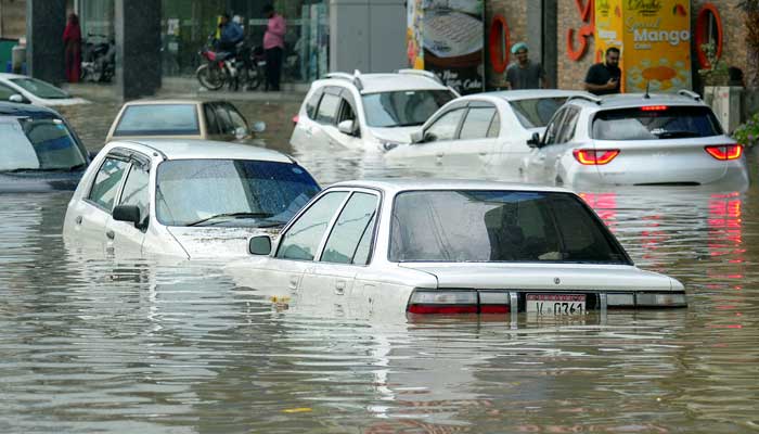 Partially submerged vehicles move, as some are parked, after the monsoon rain in Karachi, August 19, 2025. — Reuters