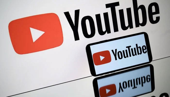 A picture taken in Toulouse shows the logo of Youtube social media displayed by a tablet and a smartphone October 5, 2021. — AFP