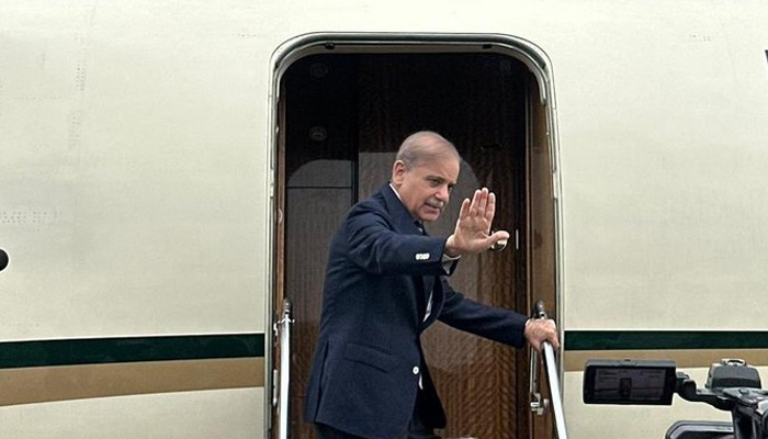 Prime Minister Shehbaz Sharif waves back at cameras while getting on his plane before his flight to China on August 30, 2025. — X@CMShehbaz