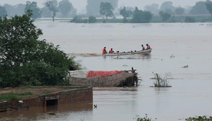 A Rescue 1122 boat eveacuates people from the flooded area past partially submerged houses in Chanda Singh Wala village near the Pakistan-India border in Kasur district of the Punjab province, August 29, 2025. — Reuters