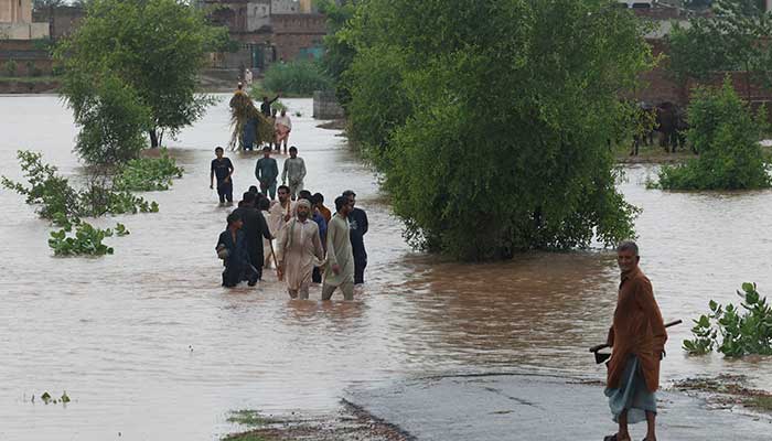 Residents wade through a flooded road, following the monsoon rains and rising water level of the Chenab River, in Patraki, Chiniot district of the Punjab on August 30, 2025. — Reuters