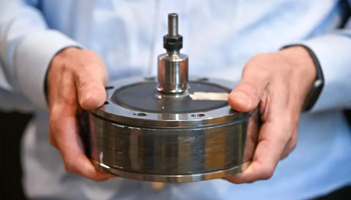 Keith Pullen, chief technical officer at Levistor, holds a flywheel inertia rotor at the companys workshop which can help bring stability to the electricity grid. — AFP