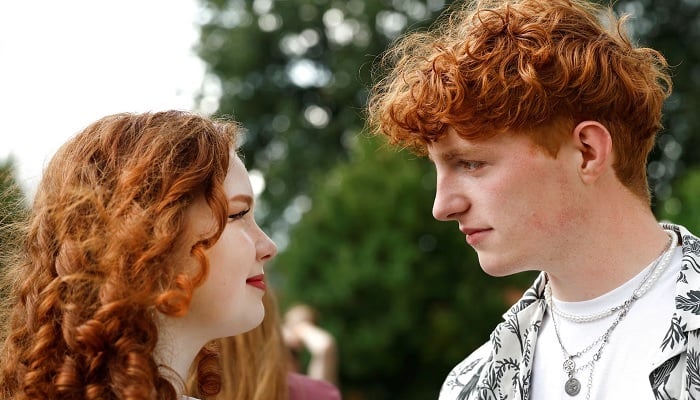 A boy looks at a girl, both from Germany, as they attend the annual Redhead Days Festival in Tilburg, Netherlands, August 27, 2023. REUTERS