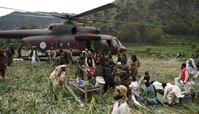 Afghan volunteers and Taliban security personnel work to move injured people near a military helicopter following earthquakes in the Mazar Dara village of Nurgal, a district of the Kunar Province, in Eastern Afghanistan, on September 1, 2025. — AFP