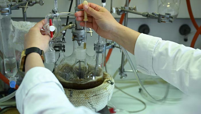 A laboratory staff member takes a sample using a pipette in the lab of Hobum Oleochemicals in Hamburg, Germany, August 25, 2025.