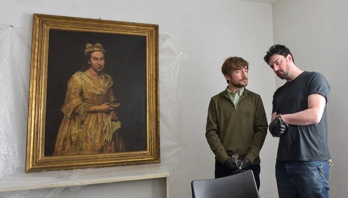 Art expert Ariel Bassano (left) with the Nazi-looted Portrait of a Lady after it was retrieved by Argentine authorities from the daughter of an SS officer in the resort of Mar del Plata. —AFP