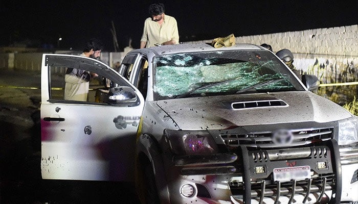 Security personnel inspect a damaged vehicle at the site of an explosion after a suicide bombing in Quetta on September 2, 2025. — AFP