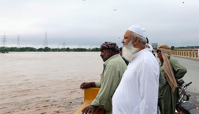 Men stand on a bridge over the Chenab River, following the monsoon rains and rising water level in Wazirabad, in Punjab province, Pakistan August 27, 2025. — Reuters