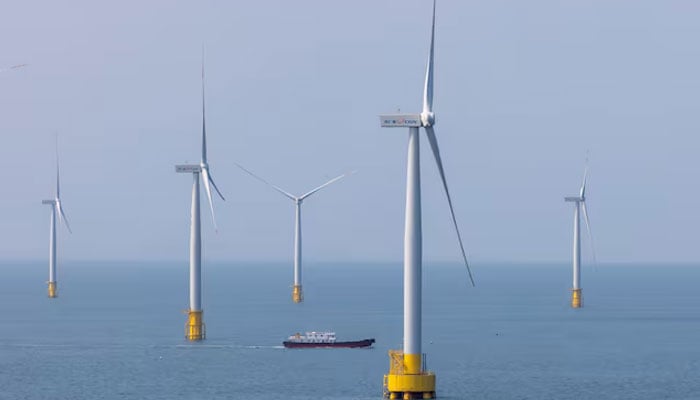 A ship sails between wind turbines in the Taiwan strait off the coast of Pingtan Island, Fujian province, China, April 10, 2023. — Reuters