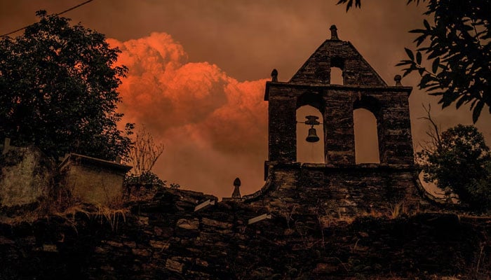 A pyrocumulus cloud forms as smoke rises from a wildfire as seen from a cemetery in the village of Vilarmel, Lugo area, Galicia region, Spain, August 16, 2025. — Reuters