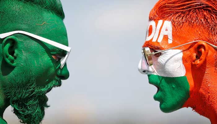Cricket fans, with their faces painted in the Pakistans and Indias flag colours, pose for a picture ahead of the first match between Pakistan and India. — Reuters/File