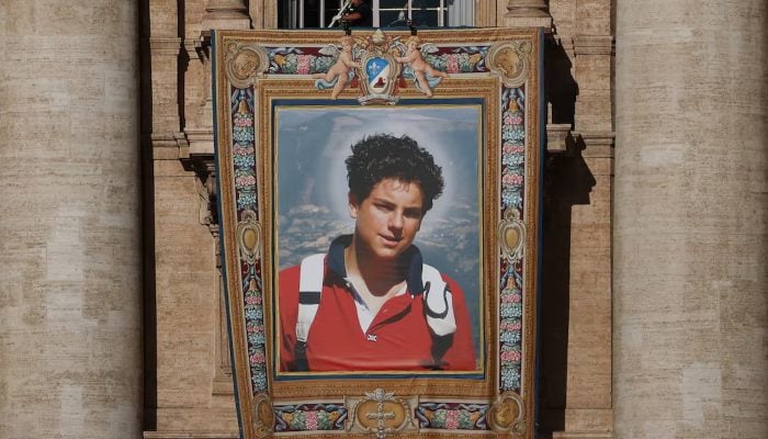 Workers install a tapestry on the facade of St Peters Basilica at the Vatican depicting an image of Carlo Acutis, a British-born Italian boy who will become the first millennial to be made a Catholic saint in a ceremony led by Pope Leo, as seen from Rome, Italy, September 4, 2025.