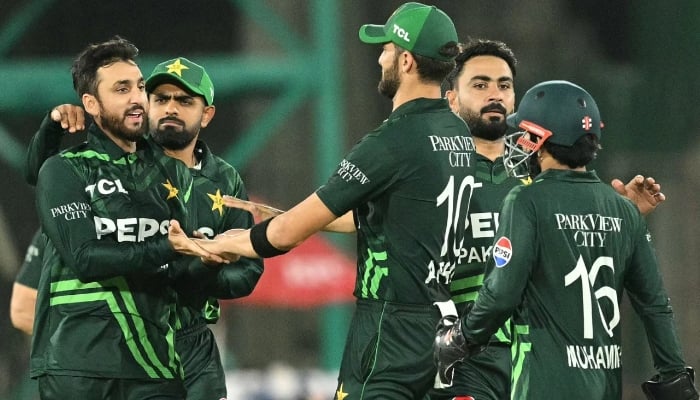 Salman Agha and Shaheen Afridi celebrate the fall of a wicket alongside their teamates, February 14, 2025. — AFP