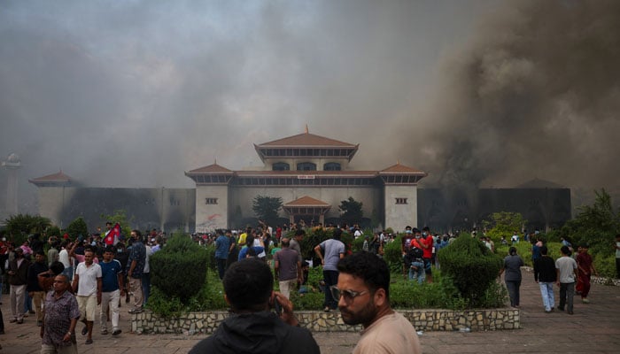 Demonstrators gather as smoke rises from the Parliament complex following a fire set during a protest against Mondays killing of 19 people after anti-corruption protests that were triggered by a social media ban, which was later lifted, during a curfew in Kathmandu, Nepal, September 9, 2025.— Reuters
