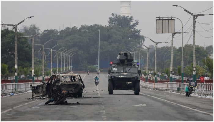 A military vehicle moves past a burnt vehicle on a road near the Singha Durbar office complex that houses the Prime Ministers office and other ministries, following protests against Mondays killing of 19 people after anti-corruption protests triggered by a social media ban which was later lifted, in Kathmandu, Nepal, September 10, 2025. — Reuters