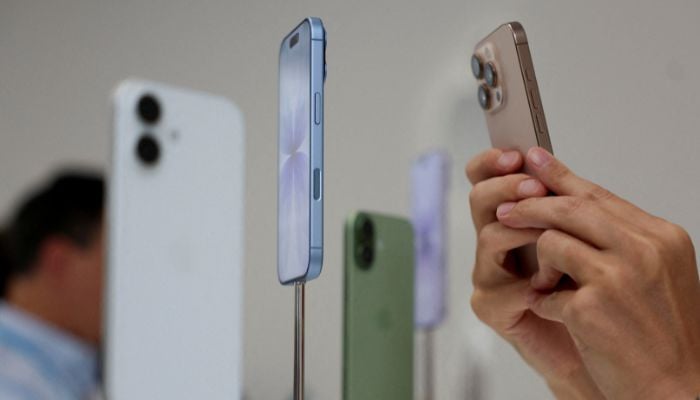 A person uses a phone to capture iPhones on display during Apples event at the Steve Jobs Theater in Cupertino, California, US, September 9, 2025. — Reuters