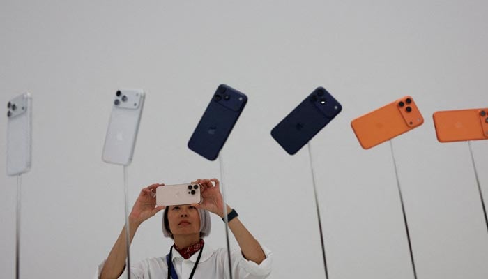 A woman takes pictures of iPhones during Apples event at the Steve Jobs Theatre in Cupertino, California, U.S., September 9, 2025. — Reuters