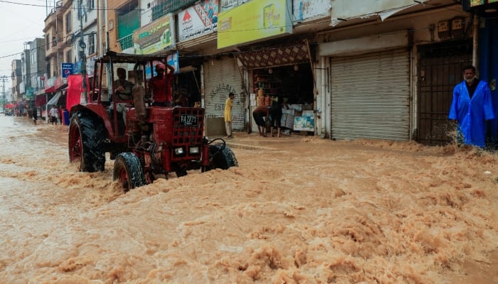 Workers use a tractor to clear a flooded street after a rain, following a recent monsoon season, in Karachi, on September 10, 2025. — Reuters