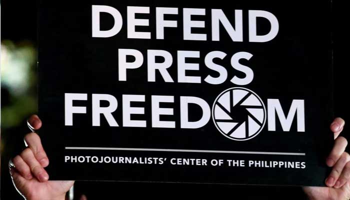 A photojournalist raises a placard in a rally for press freedom in Quezon City, Philippines. — Reuters/File