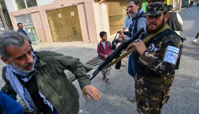 A member of Taliban special forces pushes a journalist covering a demonstration by women protesters outside a school in Kabul, Afghanistan, September 30, 2021. — AFP