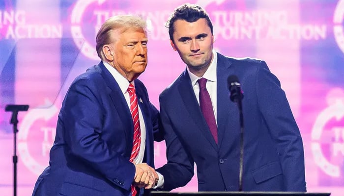 Charlie Kirk, right, speaks on stage with US President Donald Trump at AmericaFest, Turning Point USAs annual conference, in December 2024. — AFP/File