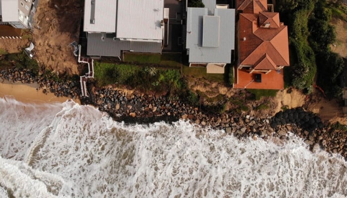 An aerial photo taken on July 28, 2020 shows homes perched on Australia’s eastern coastal town of Wamberal that are at risk of being swept away. — AFP