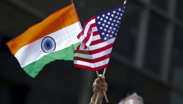 A man holds the flags of India and the US while people take part in the 35th India Day Parade in New York August 16, 2015. — Reuters