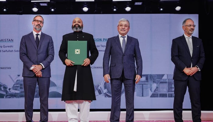 A winner from the Aga Khan Award for Architecture pose at the prize-giving ceremony at the Kyrgyz National Philharmonic Hall.