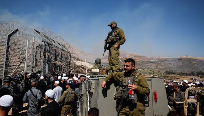Members of Israeli security forces stand at the ceasefire line between the Israeli-occupied Golan Heights and Syria, July 16, 2025. — Reuters