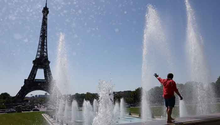 A tourist cools off in the Trocadero Fountain next to the Eiffel Tower as an early summer heatwave hits Paris, France, July 1, 2025. – Reuters