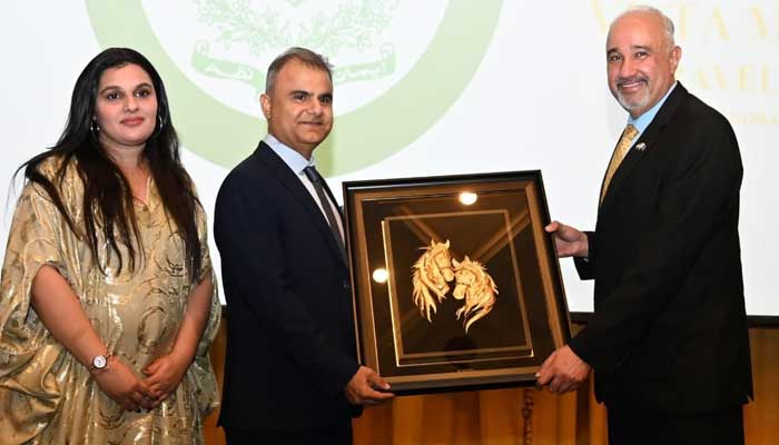 Dr Zafar Tahir presents a commemorative shield to Pakistans UAE Ambassador Faisal Tirmizi for his exceptional diplomatic services. — Reporter