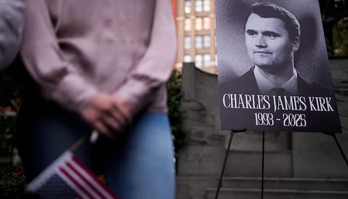 A person holds a US flag as people gather during a vigil for US right-wing activist and commentator Charlie Kirk, who was fatally shot while speaking at an outdoor event at Utah Valley University, at Madison Square Park in New York City, US, September 12, 2025. — Reuters