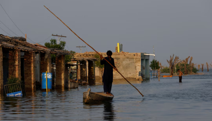 A man rows his boat as he passes through a flooded market, following rains and floods during the monsoon season in Bajara village, at the banks of Manchar lake, in Sehwan, September 6, 2022. — Reuters