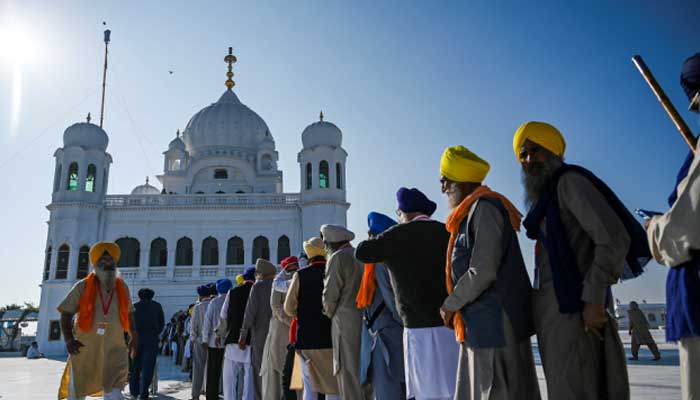 Caption: Sikh Pilgrims stand in a queue to visit the Shrine of Baba Guru Nanak Dev at Gurdwara Darbar Sahib in Kartarpur, on November 9, 2019. – AFP