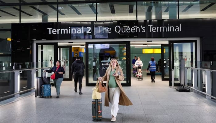 People walk at Terminal 2 of the Heathrow International Airport, near London, Britain, March 22, 2025 — Reuters