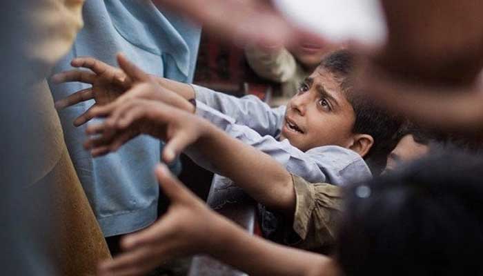 A representational image showing a child receiving food being distributed by a charity organisation. — Reuters/File