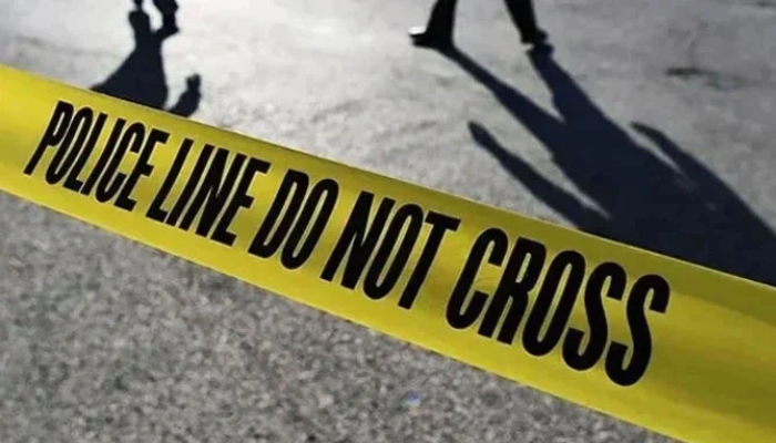 Police officers stand behind a police tape. — AFP/File