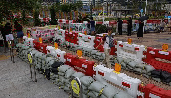 Residents walk past sandbags placed to prevent flooding from Super Typhoon Ragasa, in Hong Kong, China, September 23, 2025. — Reuters