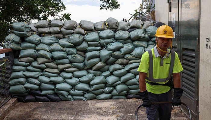 A worker stands in front of sand bags placed in preparation for Super Typhoon Ragasa, in Hong Kong, China, September 23, 2025. — Reuters