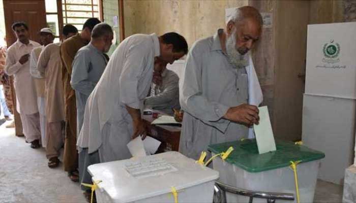 Men standing in a queue to cast their votes at a polling station.. — AFP/ File