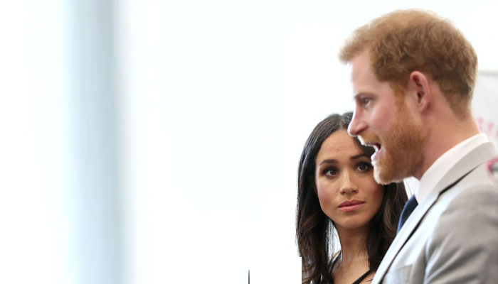 Meghan Markle watches as Prince Harry throws himself at people’s feet