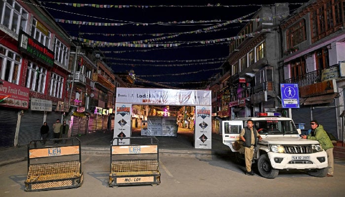 Indian policemen stand guard along a road during a curfew in Leh on September 25, 2025. — AFP