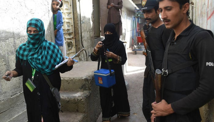 Representative image shows policemen escorting health workers during a door-to-door polio vaccination campaign in Karachi. — AFP/File