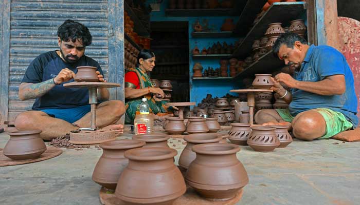 This image shows a family of clay potters molding earthen pots for sale at their workshop in the Kumbharwada potters´ colony inside Dharavi, a slum settlement in Mumbai, on July 9, 2025. — AFP