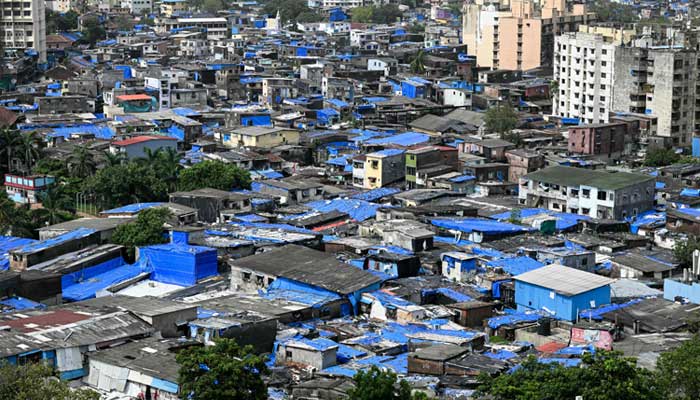 This photograph taken on July 12, 2025 shows residential buildings (back) around the cramped shanties of Dharavi, a slum settlement in Mumbai. — AFP
