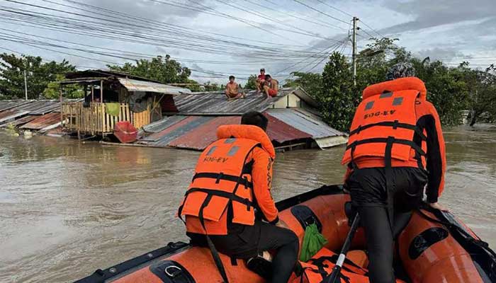 Coast guard personnel, rescuing residents from their flooded house, show the height of Severe Tropical Storm Bualoi, at a village in Ormoc City, Philippine on September 26, 2025. — AFP