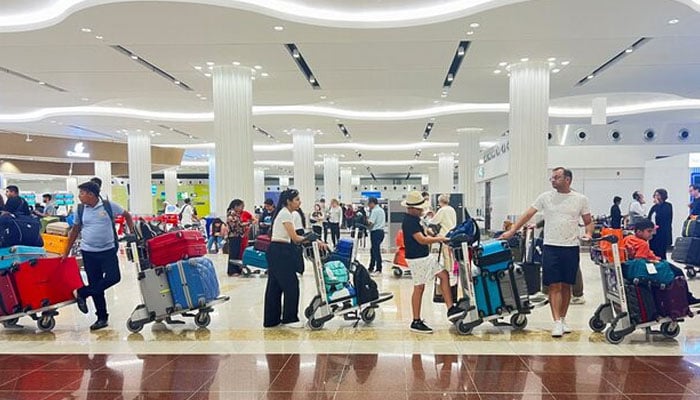 People queue at the check-in counter at the Dubai International Airport, in Dubai, United Arab Emirates, April 17, 2024. — Reuters
