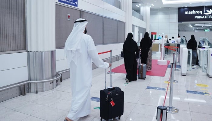 Passengers walk through Dubai International Airport’s new AI-powered Smart Red Carpet Corridor on September 27, 2025, which lets travellers clear immigration in seconds.—GDRFA Dubai