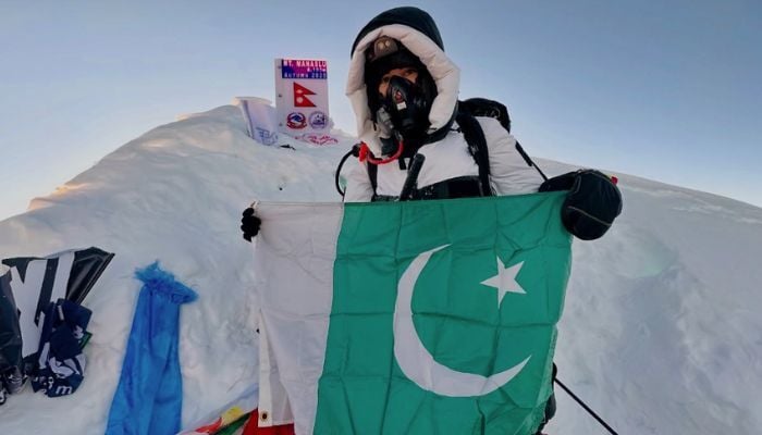 Mountaineer Nadia Azad poses with the Pakistan flag at the peak of Mount Manaslu in Nepal on September 26, 2025. — Instagram/@nadiaclimbs